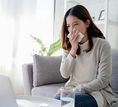 woman with allergies from her carpet and couch